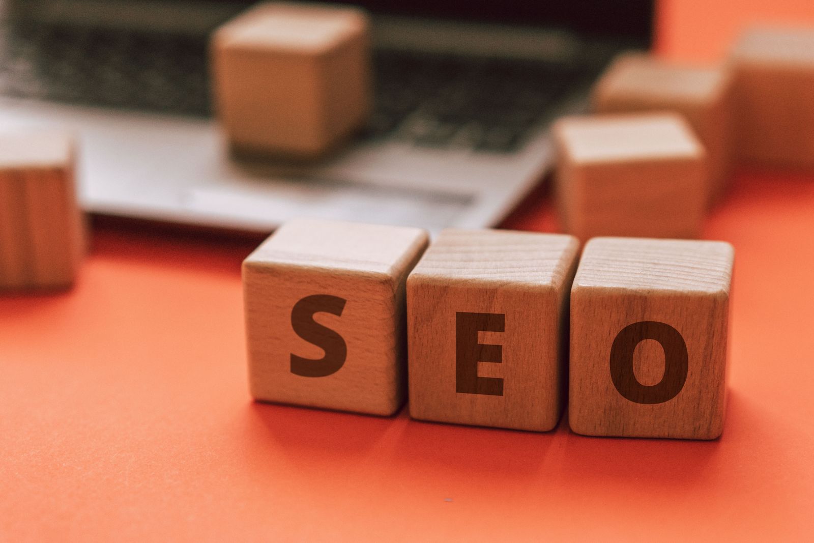 Des blocs en bois épelant SEO sur un clavier d'ordinateur portable véhiculent des concepts de marketing numérique.